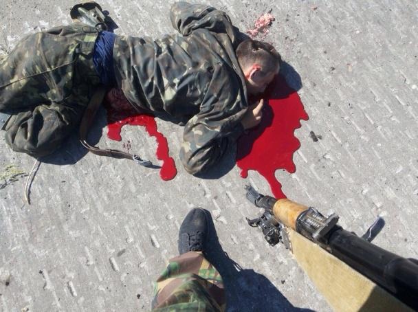 Forces spéciales de la Fédération de Russie est photographié sur fond de corps mutilés et des soldats ukrainiens piétinés sur le drapeau ukrainien. histoire de l'image Спецназ РФ фотографируется на фоне искалеченных тел украинских воинов и топчется по украинскому флагу. ФОТОрепортаж