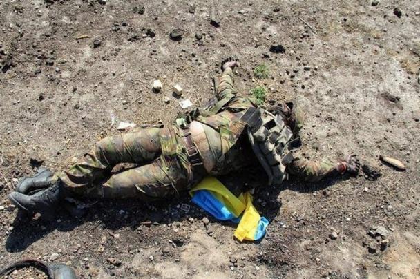 Forces spéciales de la Fédération de Russie est photographié sur fond de corps mutilés et des soldats ukrainiens piétinés sur le drapeau ukrainien. histoire de l'image Спецназ РФ фотографируется на фоне искалеченных тел украинских воинов и топчется по украинскому флагу. ФОТОрепортаж